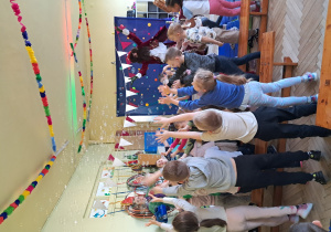 Dzieci łapią fruwające w powietrzu bańki mydlane