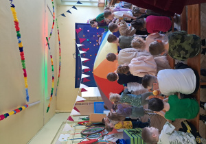 Dzieci unoszą wielką kolorową chustę