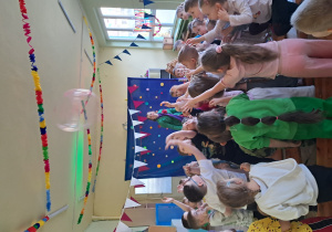 Dzieci podrzucają wysoko przezroczystą piłkę