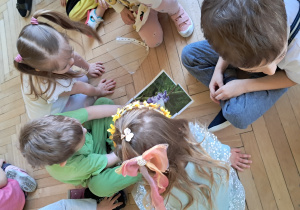 Dzieci układają obrazek kwiatków z puzzli