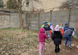 Wiele dzieci, część z nich z workami na śmieci, a część przynosi śmieci