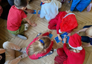 Dzieci układają puzzle z obrazkiem bałwanka