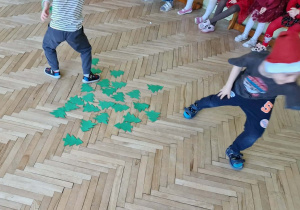 Dzieci biegną do swoich grup z papierowymi choinkami