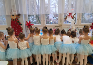 Dzieci przebrane za laleczki wyglądające przez okno